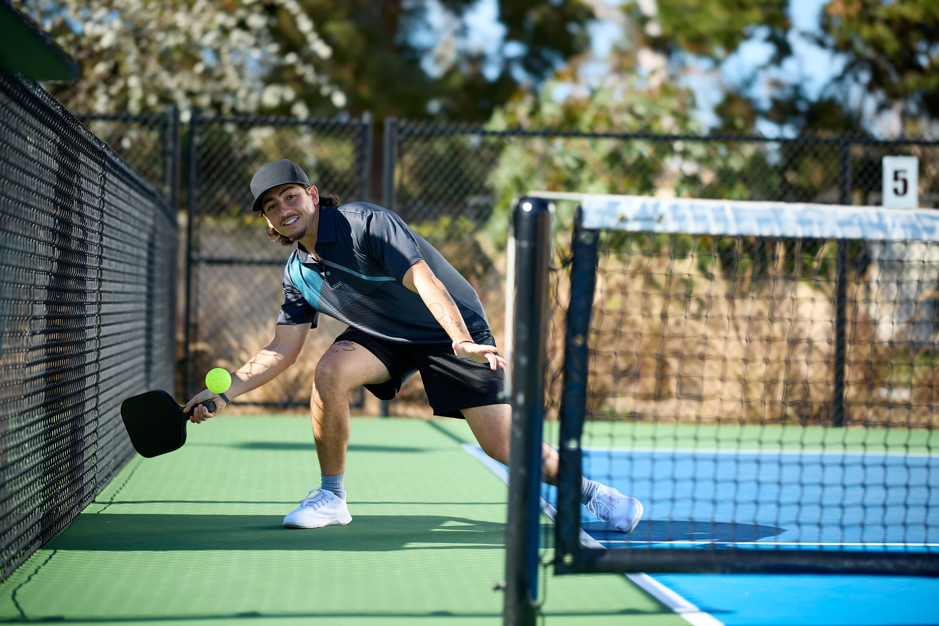 Wide view of several pickleball courts in use on a clear day